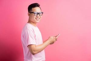 l'uomo asiatico sta usando il suo telefono per mandare sms