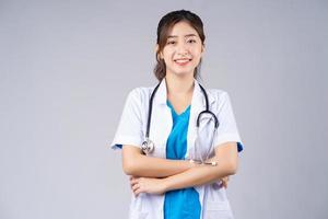 immagine di una giovane dottoressa asiatica su sfondo grigio foto