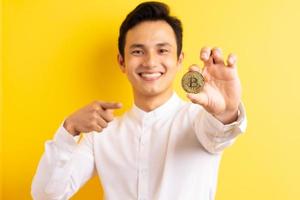 uomo d'affari asiatico che tiene bitcoin in mano wite faccia felice