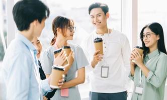 gruppo di uomini d'affari chiacchierano e bevono caffè durante la ricreazione foto