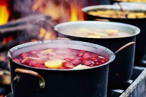 bevande frutta e frutti di bosco caldo vin brulé vino nel pentole con vapore nel strada cibo mercato. generativo ai foto