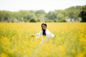 giovane donna nel campo di colza foto