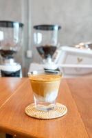 bicchiere di caffè sporco, o latte freddo condito con un caffè espresso caldo, in una caffetteria foto