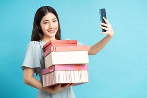 donna asiatica che tiene scatole regalo foto