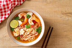 spaghetti istantanei ramen in zuppa piccante con gamberi o tom yum kung - stile asiatico foto