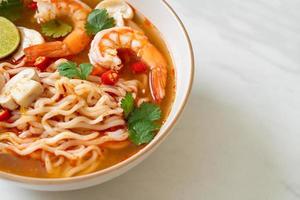 spaghetti istantanei ramen in zuppa piccante con gamberi o tom yum kung - stile asiatico foto