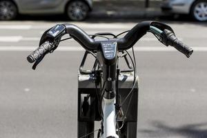 dettagli del manubrio di una bici elettrica in carica presso la sua stazione di noleggio, madrid, spagna foto