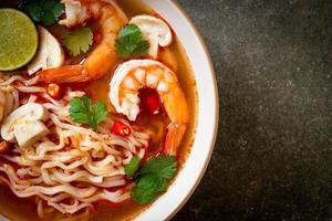 spaghetti istantanei ramen in zuppa piccante con gamberi o tom yum kung - stile asiatico foto