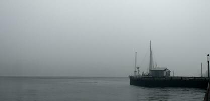 il molo il lungomare pauroso e solitario sfondo lungomare smog buio tono Immagine foto