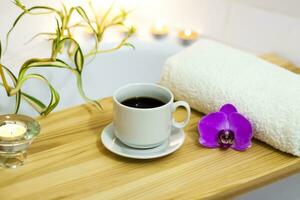 spa-bellezza salone, benessere centro. aromaterapia terme trattamento per il femmina corpo nel il bagno con un' tazza di caffè, candele, oli e sale. foto