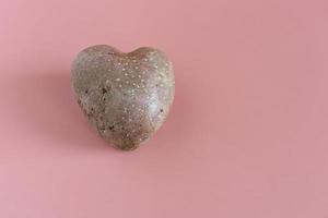 patate a forma di cuore su uno sfondo rosa. il concetto di agricoltura, raccolta, vegetarianismo. foto