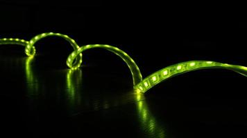 striscia decorativa led luminosa di colore verde su sfondo nero foto