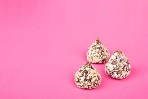 caramelle al tartufo di cioccolato con noci su sfondo rosa spazio copia