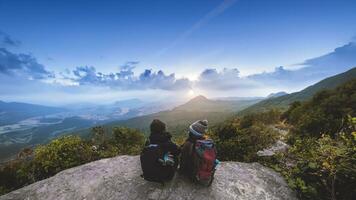 amante donne e uomini asiatici viaggiano rilassarsi durante le vacanze. ammirare l'atmosfera del paesaggio sulla montagna. parco di montagna felicemente. in Thailandia foto