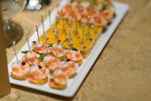 cibo a buffet, catering food party in un ristorante, mini tartine, snack e stuzzichini foto