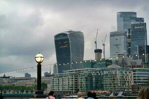 Basso angolo Visualizza di centrale Londra città a fiume Tamigi e Torre Londra ponte durante un' nuvoloso giorno di giugno 18, 2023. Londra, Inghilterra, unito regno, grande Gran Bretagna tour. foto