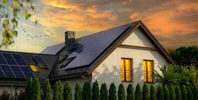 moderno Casa con solare pannelli, tramonto. solare pannelli su un' timpano tetto. grande moderno Casa. sostenibile energia foto
