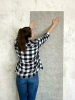 brunetta donna provando su nuovo sfondo a casa un' di recente dipinto bianca parete per visivo effetto foto