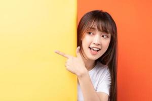 giovane ragazza asiatica che si sovrappone a sfondo giallo su sfondo arancione foto