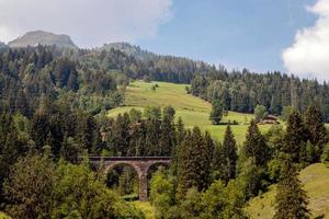 un pittoresco paesaggio alpino con un vecchio ponte ferroviario. Austria. foto