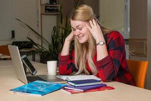 una donna bionda seduta su un laptop rotto e preoccupata. foto