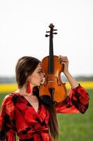 ritratto di una giovane donna positiva. parte del viso è coperta dal collo del violino - immagine foto