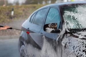 auto senza tocco lavaggio self-service. lavare con acqua e schiuma. foto