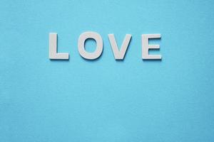 parola d'amore con lettere in legno sullo sfondo blu per san valentino foto