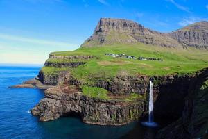 cascata mulafossur con il villaggio di gasadalur sulle isole faroe foto