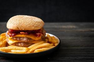 hamburger di maiale o hamburger di maiale con formaggio, pancetta e patatine fritte foto