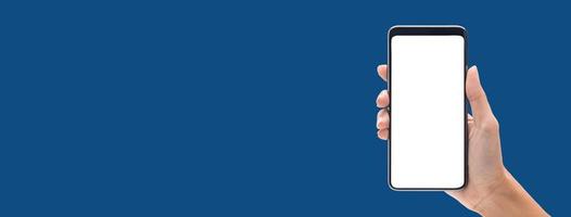 mano che tiene smartphone con schermo vuoto isolato su sfondo blu banner foto