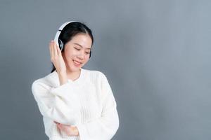 giovane donna asiatica che ascolta musica con le cuffie foto