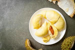 durian stagionato e fresco, buccia di durian su piatto bianco foto