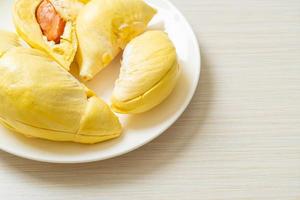 durian stagionato e fresco, buccia di durian su piatto bianco foto