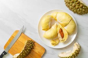 durian stagionato e fresco, buccia di durian su piatto bianco foto