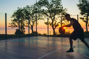 nero uomo fare gli sport, giocando pallacanestro su Alba, silhouette foto