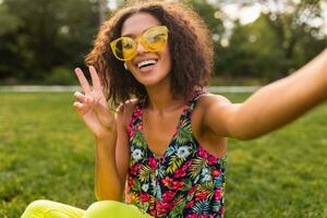 giovane elegante nero donna avendo divertimento nel parco estate moda stile foto
