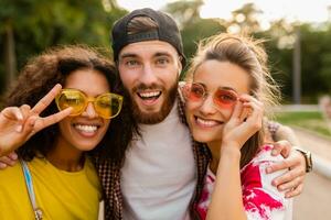 contento giovane azienda di amici avendo divertimento nel parco foto