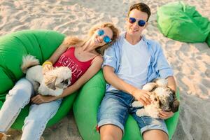 giovane attraente sorridente coppia avendo divertimento su spiaggia giocando con cani foto