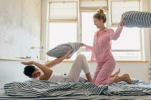 giovane coppia avendo divertimento su letto nel mattina foto