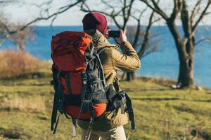 giovane fricchettone uomo in viaggio con zaino nel freddo stagione foto