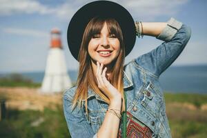 giovane donna nel natura, faro denim giacca, nero cappello, estate, elegante Accessori foto