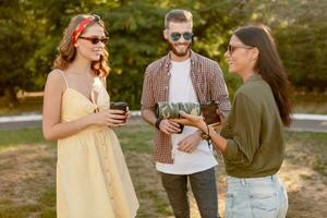 azienda di amici avendo divertimento insieme nel parco ascoltando per musica foto