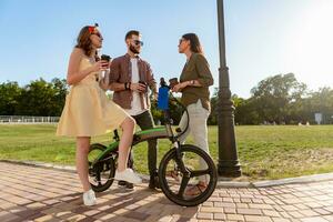 azienda di amici avendo divertimento insieme nel parco ascoltando per musica foto