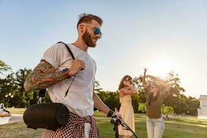 azienda di amici avendo divertimento insieme nel parco ascoltando per musica foto