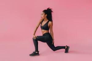 attraente nero africano americano donna nel nero leggins fitness attrezzatura su rosa sfondo foto