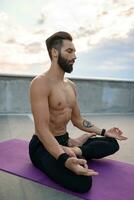 attraente bello uomo con atletico forte corpo fare mattina yoga dzen meditazione foto