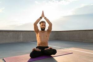 attraente bello uomo con atletico forte corpo fare mattina yoga dzen meditazione foto