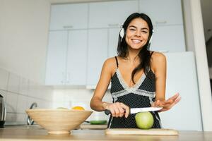 attraente sorridente donna nel pigiama avendo prima colazione nel cucina foto