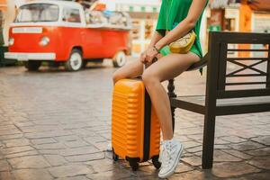 donna viaggiatore con arancia valigia, in viaggio in giro mondo foto
